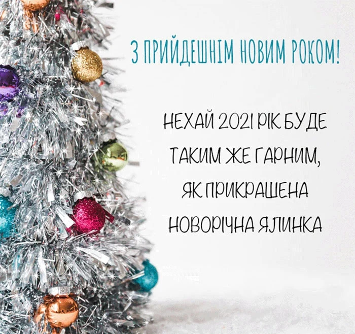Срібна ялинка з прикрасами та побажаннями на Новий рік.