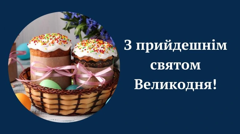 Пасхальні куличі в кошику з яйцями та квітами.