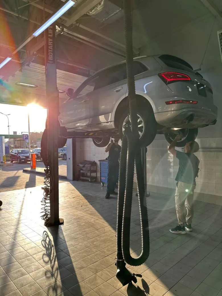 Механіки обслуговують автомобіль на підйомнику в автосервісі