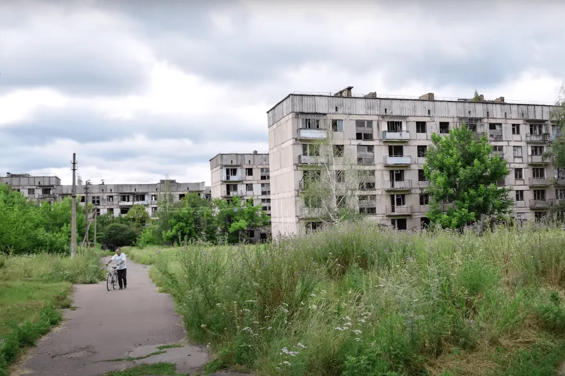 Покинуті житлові будинки та людина на велосипеді