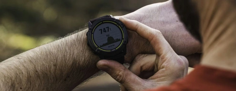 Чоловік дивиться на годинник Garmin Enduro з картою висоти.